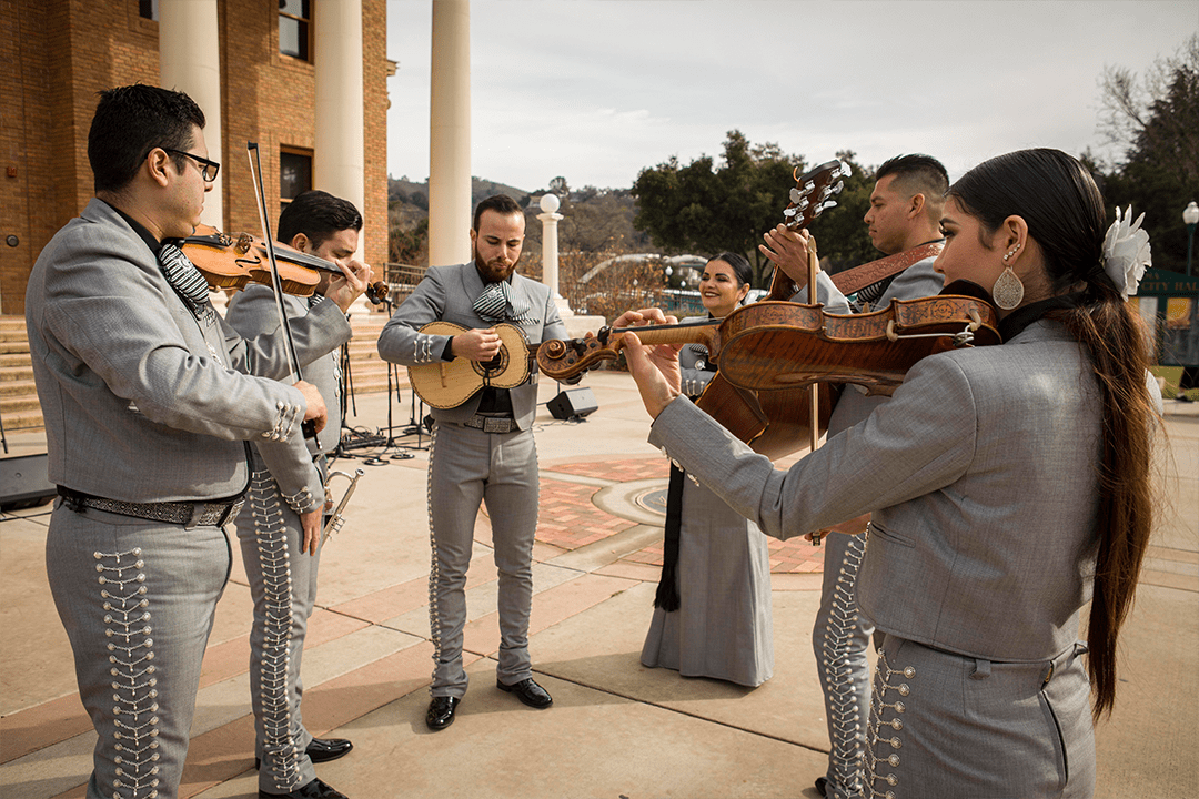 Image of Mariachi Voces Tapatias Band playing a variety of instruments in front of City Hall
